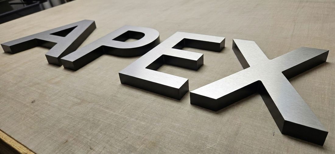 Brushed metal dimensional letters mounted on a wall
